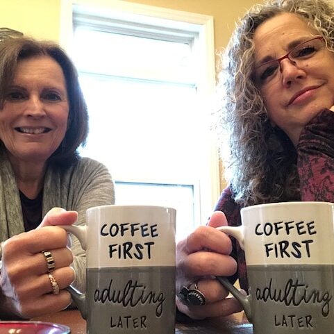 Two women holding Adulting mugs
