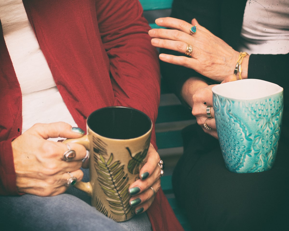 Hands holding coffee mugs in therapy session